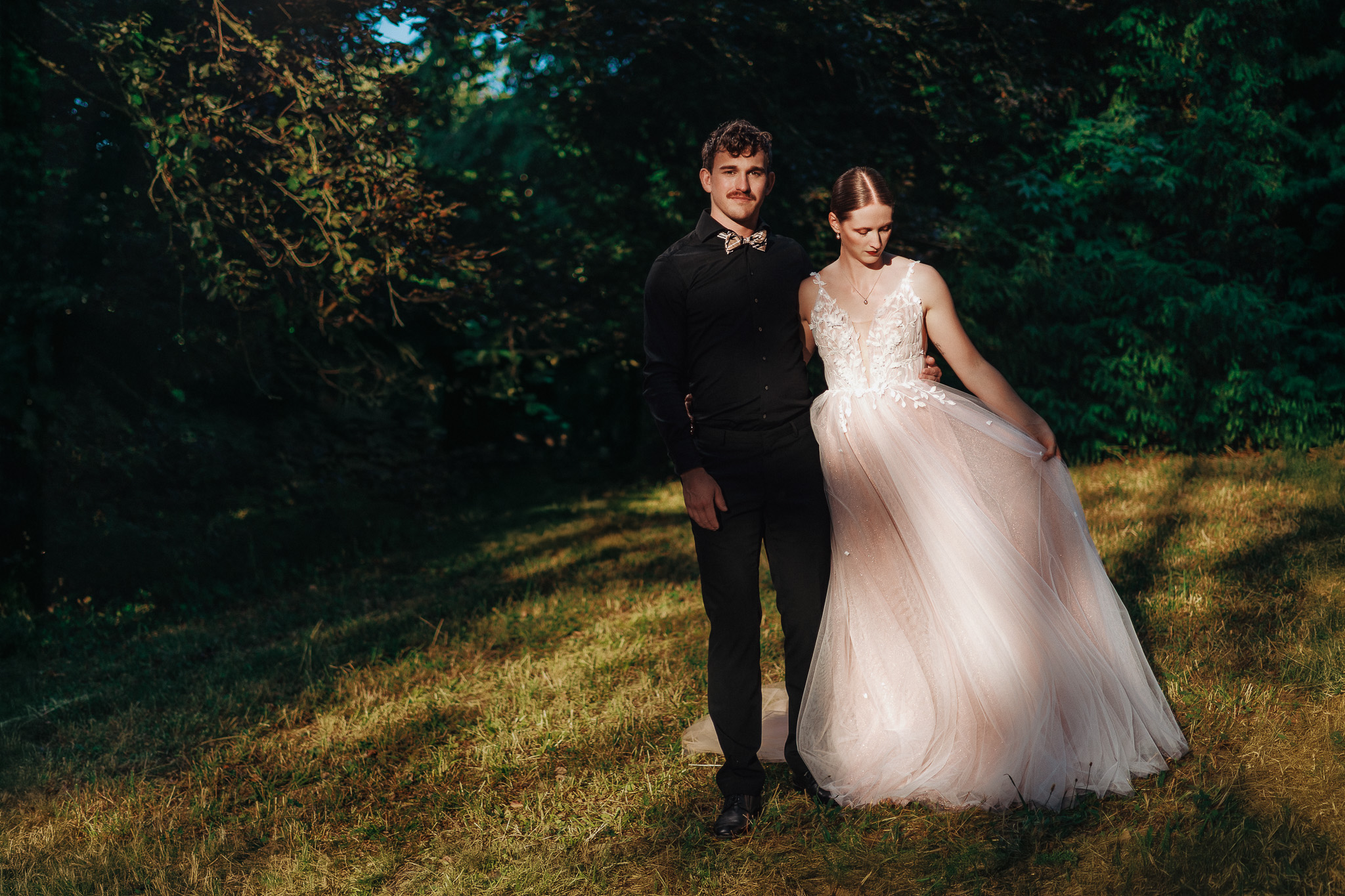 Eleganter Tanz an Sommerhochzeit unter den Bäumen, das Licht flimmert